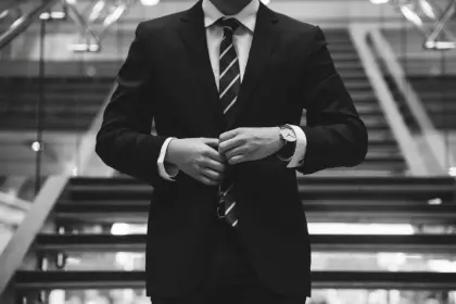 Man in a suit adjusting his jacket buttons